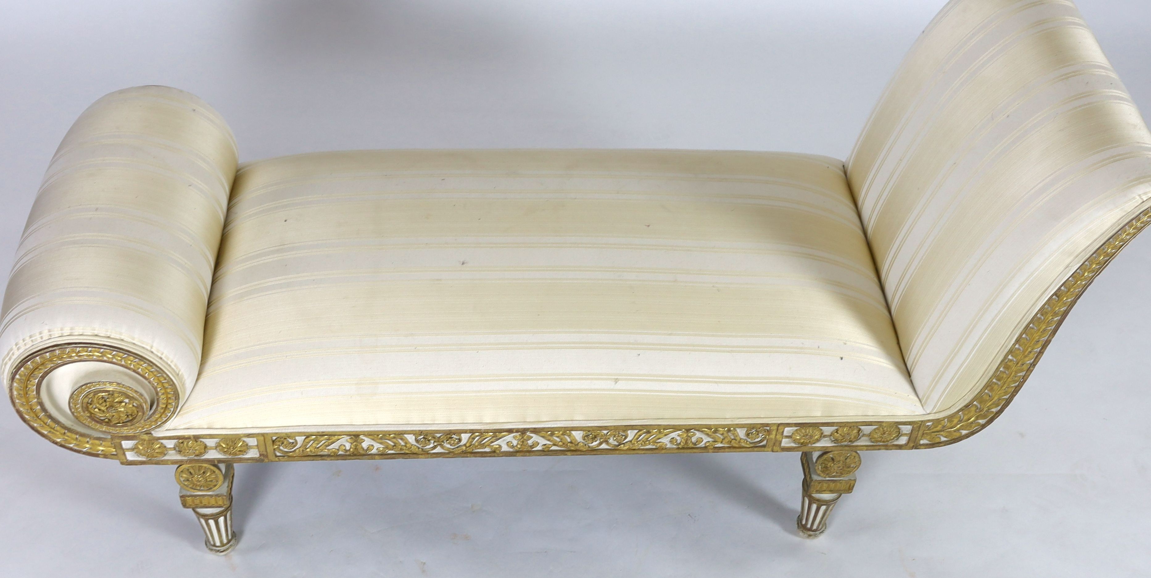 A Regency white painted and parcel gilt chaise longue, L.166cm W.63cm H.84cm